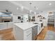 Open-concept kitchen with a large island, stainless steel appliances, and hardwood floors, flowing into the living area with a fireplace at 708 Cross Trail Dr, Charlotte, NC 28204
