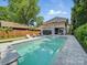 Backyard oasis with a large pool, spa, lounge chairs, and covered patio, perfect for outdoor entertaining and relaxation at 708 Cross Trail Dr, Charlotte, NC 28204
