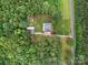 Aerial view of a home with an expansive yard, mature trees, outbuildings, and a long driveway at 733 Killian Rd, Stanley, NC 28164