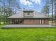 This spacious backyard boasts a brick home, large deck, and well-maintained lawn with mature trees at 733 Killian Rd, Stanley, NC 28164