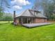A backyard features an expansive deck and brick home with well-manicured lawn surrounded by mature trees at 733 Killian Rd, Stanley, NC 28164