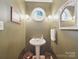 Half bathroom featuring pedestal sink and decorative mirror at 733 Killian Rd, Stanley, NC 28164
