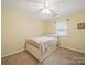 A bright bedroom with a ceiling fan, a neutral color scheme, and a charming wooden bed frame at 733 Killian Rd, Stanley, NC 28164