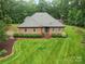 Lovely brick home surrounded by mature trees, a well-maintained lawn, and colorful landscaping at 733 Killian Rd, Stanley, NC 28164