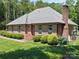 Brick home with mature landscaping, lush lawn and brick chimney at 733 Killian Rd, Stanley, NC 28164