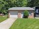 A well-maintained brick garage with a lush lawn, accented by a vibrant green bush at 733 Killian Rd, Stanley, NC 28164