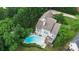 Aerial view showcasing a lovely home, backyard swimming pool, deck, and lush green landscape at 7704 Ninth Fairway Ln, Mint Hill, NC 28227
