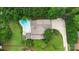 Aerial view of a backyard featuring a pool, deck, and well-manicured lawn, surrounded by trees at 7704 Ninth Fairway Ln, Mint Hill, NC 28227