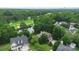 Aerial view of a luxurious home nestled among lush trees and a nearby golf course at 7704 Ninth Fairway Ln, Mint Hill, NC 28227