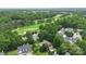 Stunning aerial view of a home adjacent to a lush golf course and a serene water feature at 7704 Ninth Fairway Ln, Mint Hill, NC 28227