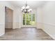 Bright, airy dining room with large window, neutral walls, and modern flooring; chandelier and molding details at 7704 Ninth Fairway Ln, Mint Hill, NC 28227