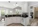 Bright kitchen featuring white cabinets, dark countertops, stainless steel sink, and a breakfast nook at 7704 Ninth Fairway Ln, Mint Hill, NC 28227