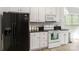 Kitchen with white cabinets, granite countertops, and appliances, including a black refrigerator and white oven at 7704 Ninth Fairway Ln, Mint Hill, NC 28227