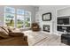 Bright living room with fireplace, large windows, and views of the water at 7704 Ninth Fairway Ln, Mint Hill, NC 28227