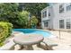 Backyard pool with patio furniture, surrounded by lush greenery and a well-maintained lawn at 7704 Ninth Fairway Ln, Mint Hill, NC 28227