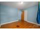Simple bedroom with hardwood floors, light blue walls, and a closet, providing a cozy and functional space at 810 Surry Dr, Shelby, NC 28152