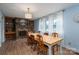 Bright dining room with hardwood floors, white curtains, a brick fireplace, and a wooden dining table at 810 Surry Dr, Shelby, NC 28152