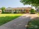 Long driveway leading to a charming brick home with lovely landscaping at 810 Surry Dr, Shelby, NC 28152