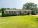 Charming brick home with a well-manicured lawn, mature shrubs, and a convenient carport offers classic curb appeal at 810 Surry Dr, Shelby, NC 28152