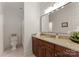Well-lit bathroom featuring dark wood cabinets, a granite countertop, and a large mirror over the vanity at 901 Hartford Ave, Charlotte, NC 28209