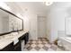 Elegant bathroom featuring dual sinks, granite counters, a large framed mirror, and decorative tile flooring at 901 Hartford Ave, Charlotte, NC 28209