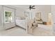 Airy bedroom with large windows, ceiling fan, neutral decor, bench, and a view of the outside, creating a cozy space at 901 Hartford Ave, Charlotte, NC 28209