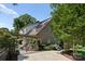 Rear exterior view showcasing a brick home with a pergola-covered patio and beautifully landscaped garden with hydrangeas at 901 Hartford Ave, Charlotte, NC 28209