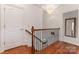 Hallway featuring a wooden staircase with iron railings, and hardwood floors at 901 Hartford Ave, Charlotte, NC 28209
