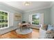 Stylish home office with a light blue accent wall, hardwood floors, and windows with white shutters to allow natural light at 901 Hartford Ave, Charlotte, NC 28209