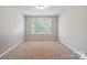 Bright, carpeted bedroom with natural light from the window at 10012 Michael Crossing Dr, Charlotte, NC 28213