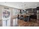 Modern kitchen boasts dark cabinets, granite countertops, pendant lighting, and seamless flow to the outdoor patio at 10012 Michael Crossing Dr, Charlotte, NC 28213