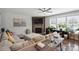 Comfortable living room featuring a stone fireplace, large windows, and a sectional sofa at 10012 Michael Crossing Dr, Charlotte, NC 28213