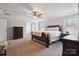 Relaxing main bedroom with a comfortable bed, dark wood furniture, and soft carpet at 10012 Michael Crossing Dr, Charlotte, NC 28213