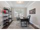 Well-lit office with a modern desk, ergonomic chair, stylish bookshelf, and contemporary artwork at 10012 Michael Crossing Dr, Charlotte, NC 28213