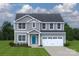 Inviting two-story home featuring gray siding, a lovely front door, and a convenient two-car garage at 10112 Florentine Ln, Charlotte, NC 28214