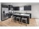 Modern kitchen featuring black cabinetry, stainless steel appliances, a kitchen island, and wood-look flooring at 10112 Florentine Ln, Charlotte, NC 28214