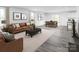 Spacious living room with a leather sofa, ottoman, neutral decor, and an adjacent dining area at 10112 Florentine Ln, Charlotte, NC 28214