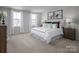 Serene main bedroom with plush carpeting, two windows, and stylish nightstands, offering a relaxing retreat at 10112 Florentine Ln, Charlotte, NC 28214