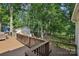 Multi-level backyard deck with stairs and wood railings with views of mature trees and the lake at 10311 Windtree Ln, Charlotte, NC 28215
