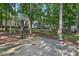 Backyard featuring a concrete basketball court and mature trees providing ample shade at 10311 Windtree Ln, Charlotte, NC 28215