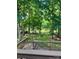 A view from the deck shows a spacious backyard with mature trees and lake, with string lights at 10311 Windtree Ln, Charlotte, NC 28215