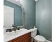 A modern bathroom featuring a white vanity, modern mirror, and a toilet at 10311 Windtree Ln, Charlotte, NC 28215