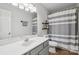 A spacious bathroom featuring a vanity, large mirror, and a shower with a striped curtain at 10311 Windtree Ln, Charlotte, NC 28215