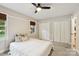 This bedroom features carpeted floors, a ceiling fan, and dual closets for ample storage at 10311 Windtree Ln, Charlotte, NC 28215