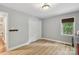 A clean bedroom featuring hardwood floors, neutral walls, and a window overlooking the backyard at 10311 Windtree Ln, Charlotte, NC 28215