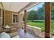 Inviting front porch with brick facade, wooden pillars, and view of the landscaped front yard at 10311 Windtree Ln, Charlotte, NC 28215