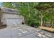 Spacious two-car garage with a concrete driveway surrounded by lush greenery and mature trees at 10311 Windtree Ln, Charlotte, NC 28215