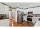 Bright kitchen with stainless steel appliances, white cabinets, and view to the dining room at 10311 Windtree Ln, Charlotte, NC 28215