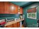 Office featuring built in cabinets, dark green walls, and an exterior view from the window at 10311 Windtree Ln, Charlotte, NC 28215