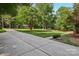 Expansive landscaped front yard with mature trees and a long driveway at 10311 Windtree Ln, Charlotte, NC 28215